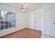 Bedroom with wood floors, ceiling fan, window and white walls at 4702 Kati Lynn Dr, Apopka, FL 32712