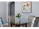 Dining room with a glass table, four upholstered chairs and an artistic wall hanging at 487 La Mirage St, Davenport, FL 33897