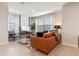 Bright living room featuring tile floors, leather sofa, and large windows dressed with flowing white curtains at 512 Preston Cove Dr, St Cloud, FL 34771