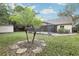 Backyard view showcases a screened-in patio, mature landscaping, palm trees, and storage shed at 5247 Secluded Oaks Dr, Orlando, FL 32812