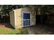 Outdoor storage shed with blue door and a gabled roof in a grassy backyard at 5247 Secluded Oaks Dr, Orlando, FL 32812