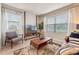 Well-lit living room featuring a tan leather sofa, modern furniture, large windows, and stylish decor at 532 Preston Cove Dr, St Cloud, FL 34771