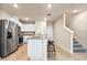 Kitchen featuring stainless steel appliances, an island with barstool seating, and a view of the carpeted stairs at 5669 Brosnan Rd, St Cloud, FL 34771