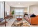 Bright living room featuring a tan leather sofa, accent chair, and stylish decor at 5669 Brosnan Rd, St Cloud, FL 34771