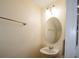 Powder room featuring a pedestal sink, oval mirror, and decorative lighting fixture at 6855 Sperone St, Orlando, FL 32819