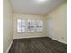 Bright bedroom with shuttered windows, wood-look flooring, and neutral wall color at 6855 Sperone St, Orlando, FL 32819