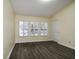 An empty bedroom with neutral walls, hardwood floors, and bright windows with plantation shutters at 6855 Sperone St, Orlando, FL 32819