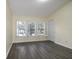 Bright bedroom boasts wood-look floors and large windows with white shutters at 6855 Sperone St, Orlando, FL 32819