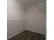 Walk-in closet features neutral paint, wood-look floors, and ample shelving at 6855 Sperone St, Orlando, FL 32819