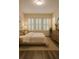 Bright main bedroom featuring three windows and stylish neutral decor and furnishings at 6855 Sperone St, Orlando, FL 32819