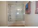 Shower enclosed with glass door with white tile, shower head, and fixtures at 6855 Sperone St, Orlando, FL 32819