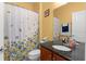 Bathroom with granite countertop vanity and shower with floral curtain at 7736 Brofield Ave, Windermere, FL 34786