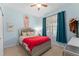 Bright bedroom featuring a ceiling fan, window with curtains, and colorful decorative accents at 7736 Brofield Ave, Windermere, FL 34786