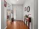 Bright foyer with hardwood floors, decorative table, and sidelight window bringing light to the front door at 7736 Brofield Ave, Windermere, FL 34786