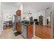 Spacious kitchen open to the living room featuring stainless steel appliances and dark wood cabinets at 7736 Brofield Ave, Windermere, FL 34786