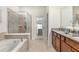 Spacious bathroom featuring a soaking tub, shower, double vanity, and an abundance of natural light at 8874 Qin Loop, Kissimmee, FL 34747