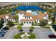 Aerial view of the community clubhouse, parking lot, lake and fountain, and nearby pool at 8940 Rhodes St, Kissimmee, FL 34747