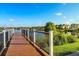 Community dock overlooking a scenic lake with lush greenery and charming homes in the background at 8940 Rhodes St, Kissimmee, FL 34747