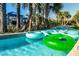 Inviting lazy river with floating tubes winding through lush landscaping and palm trees at 8940 Rhodes St, Kissimmee, FL 34747