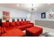 Living room features a red sectional sofa, unique wall decor and stylish overhead lighting at 8940 Rhodes St, Kissimmee, FL 34747