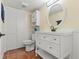 Well-lit bathroom featuring a white vanity, round mirror, and ample storage space, complete with terracotta tile flooring at 90 Cedar Dunes Dr, New Smyrna Beach, FL 32169