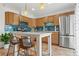 Bright kitchen with wooden cabinets, stainless steel appliances, and a white kitchen island with barstool seating at 90 Cedar Dunes Dr, New Smyrna Beach, FL 32169