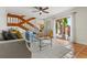 Cozy living room featuring a staircase, terracotta tile flooring, neutral furniture, and access to an outdoor patio at 90 Cedar Dunes Dr, New Smyrna Beach, FL 32169