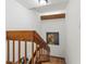 Bright stairway with terracotta tile steps and a wooden railing leads upstairs with art and a wooden beam on the wall at 90 Cedar Dunes Dr, New Smyrna Beach, FL 32169