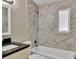 Modern bathroom features marble tile, a tub, a dark countertop, and contemporary fixtures at 906 Ferndell Rd, Orlando, FL 32808