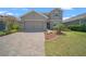 Charming two-story home featuring a two-car garage, manicured lawn, and decorative landscaping at 9180 Carmela Ave, Davenport, FL 33897