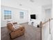 Upstairs living room area bathed in natural light, featuring a comfortable couch and a mounted TV at 9180 Carmela Ave, Davenport, FL 33897