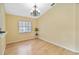 Dining area with wood floors, chandelier, and large window, adjacent to the kitchen at 9307 Echo Run, Orlando, FL 32817