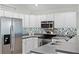 Modern kitchen featuring stainless steel appliances, mosaic backsplash, and light grey countertops at 9848 Nonacrest Dr, Orlando, FL 32832