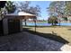 Expansive backyard overlooking a serene lake, complemented by a shed and shaded seating area, ideal for relaxation at 1104 Southampton Dr # 3, Port Orange, FL 32129