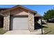 Attached garage with stone accent, showing address number over garage door at 1104 Southampton Dr # 3, Port Orange, FL 32129