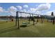 Community playground featuring swings and a slide surrounded by artificial turf and a view of the pond at 1104 Southampton Dr # 3, Port Orange, FL 32129