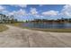 Scenic view of the community pond with a fountain, surrounded by lush landscaping and a paved walkway at 1104 Southampton Dr # 3, Port Orange, FL 32129