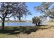 Scenic view of a tranquil pond surrounded by lush green grass and mature trees under a bright blue sky at 1104 Southampton Dr # 3, Port Orange, FL 32129