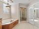 Bathroom with a soaking tub, walk-in shower, and decorative light fixture at 1110 W Ivanhoe Blvd # 5, Orlando, FL 32804