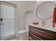 Bathroom featuring a modern vanity, round mirror, and door to the outside at 12104 Lakeshore Dr, Clermont, FL 34711