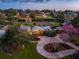 Elegant single-story home with lush landscaping, a circular driveway, and mature trees, illuminated at dusk at 12104 Lakeshore Dr, Clermont, FL 34711