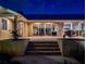 Backyard view with a lit patio and stairs leading to the main back entrance, visible through large glass windows at 12104 Lakeshore Dr, Clermont, FL 34711