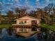 Unique waterfront home with a deck and serene water views, reflected beautifully on the calm lake at 12104 Lakeshore Dr, Clermont, FL 34711