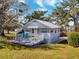 Quaint one-story cottage with a white picket fence and a cozy front porch at 12104 Lakeshore Dr, Clermont, FL 34711