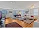 Open-concept living room featuring hardwood floors, white sofas, a dining area, and natural light at 12104 Lakeshore Dr, Clermont, FL 34711