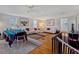 Bright living room with hardwood floors, white sofas, a dining area, and stairway access at 12104 Lakeshore Dr, Clermont, FL 34711