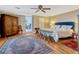 Main bedroom with wood floors, ceiling fan, and view of the home office through doorway at 12104 Lakeshore Dr, Clermont, FL 34711