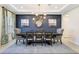 Elegant dining room with a statement light fixture, a dark accent wall, and a large decorative mirror at 1324 Arklow Cir, Ormond Beach, FL 32174