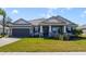 Charming single-story home featuring a well-manicured lawn, two-car garage, and inviting front porch at 1324 Arklow Cir, Ormond Beach, FL 32174