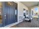 Inviting front porch with a cozy seating area, decorative brickwork, and stylish front door at 1324 Arklow Cir, Ormond Beach, FL 32174